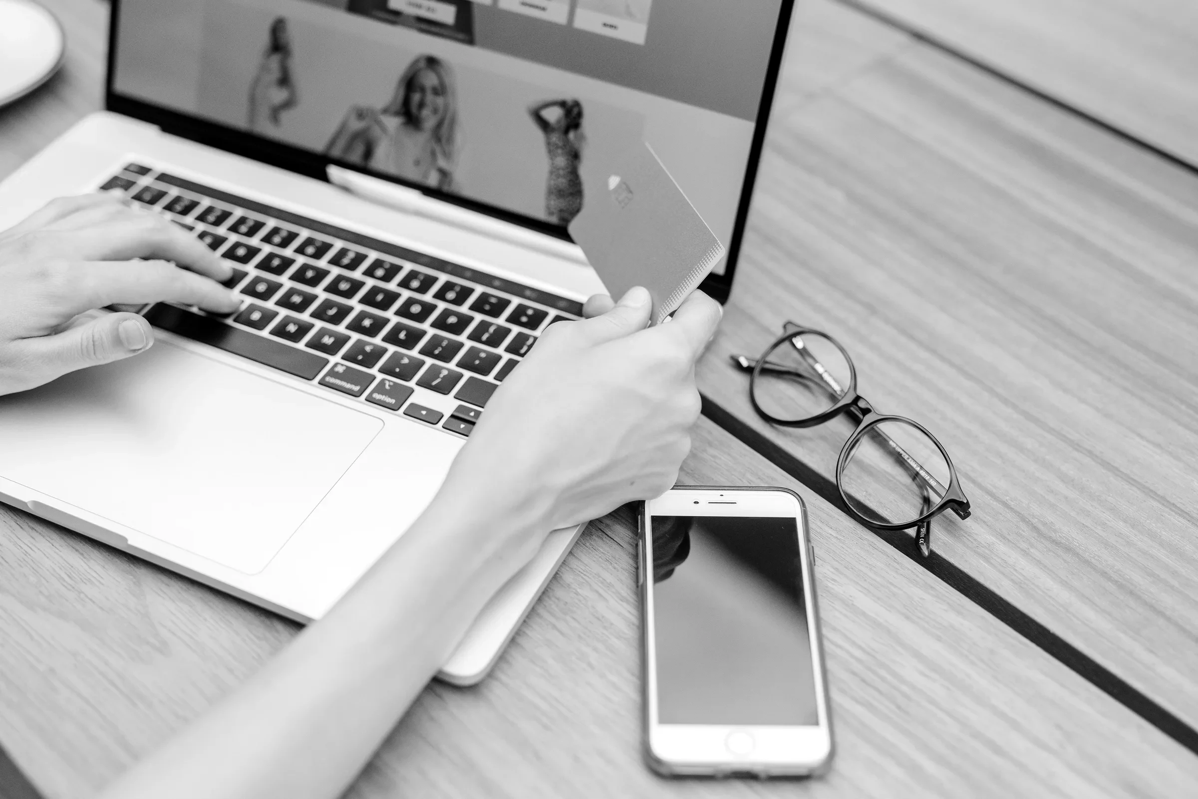 Completing an online checkout beside a laptop