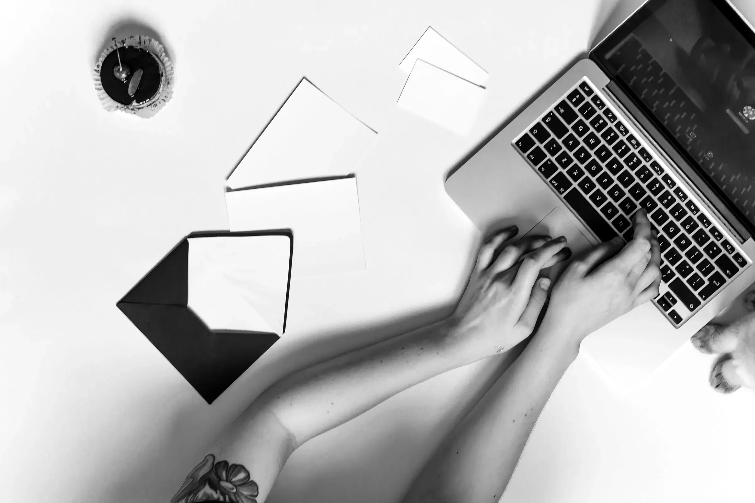 Typing on a laptop surrounded by envelopes