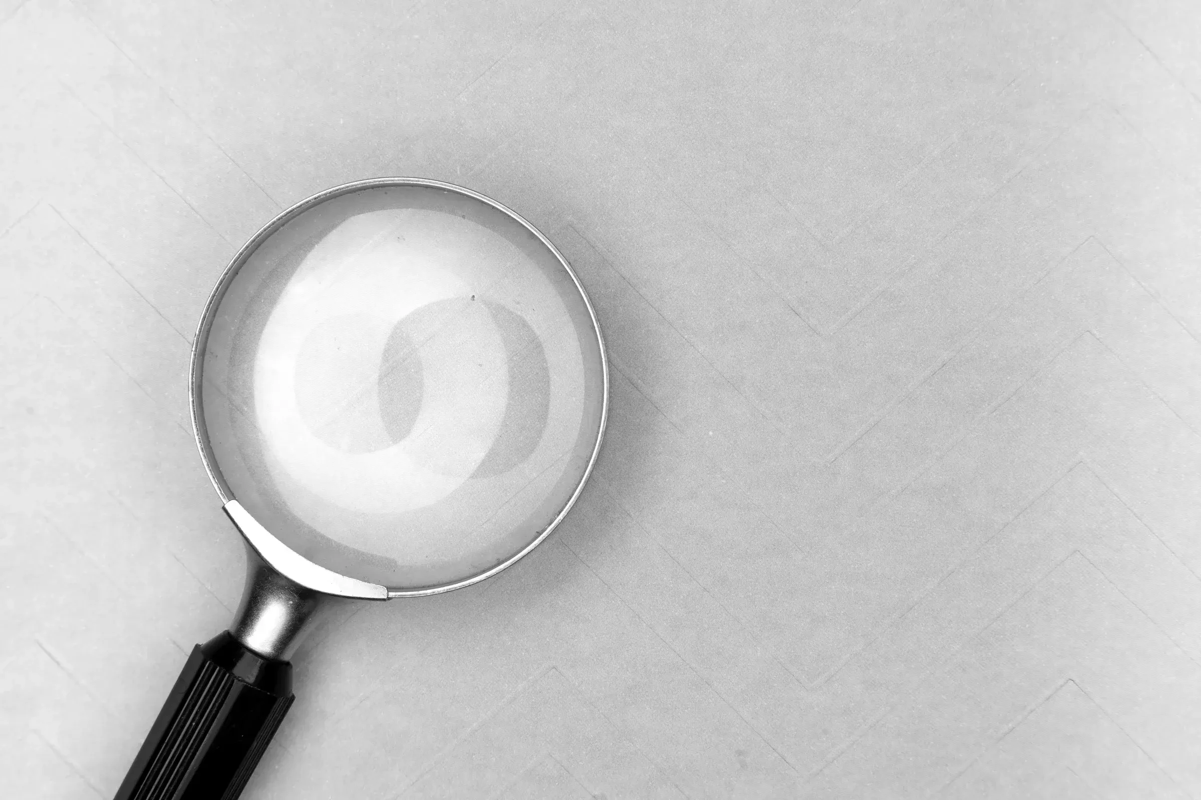 A magnifying glass on a plain blue background