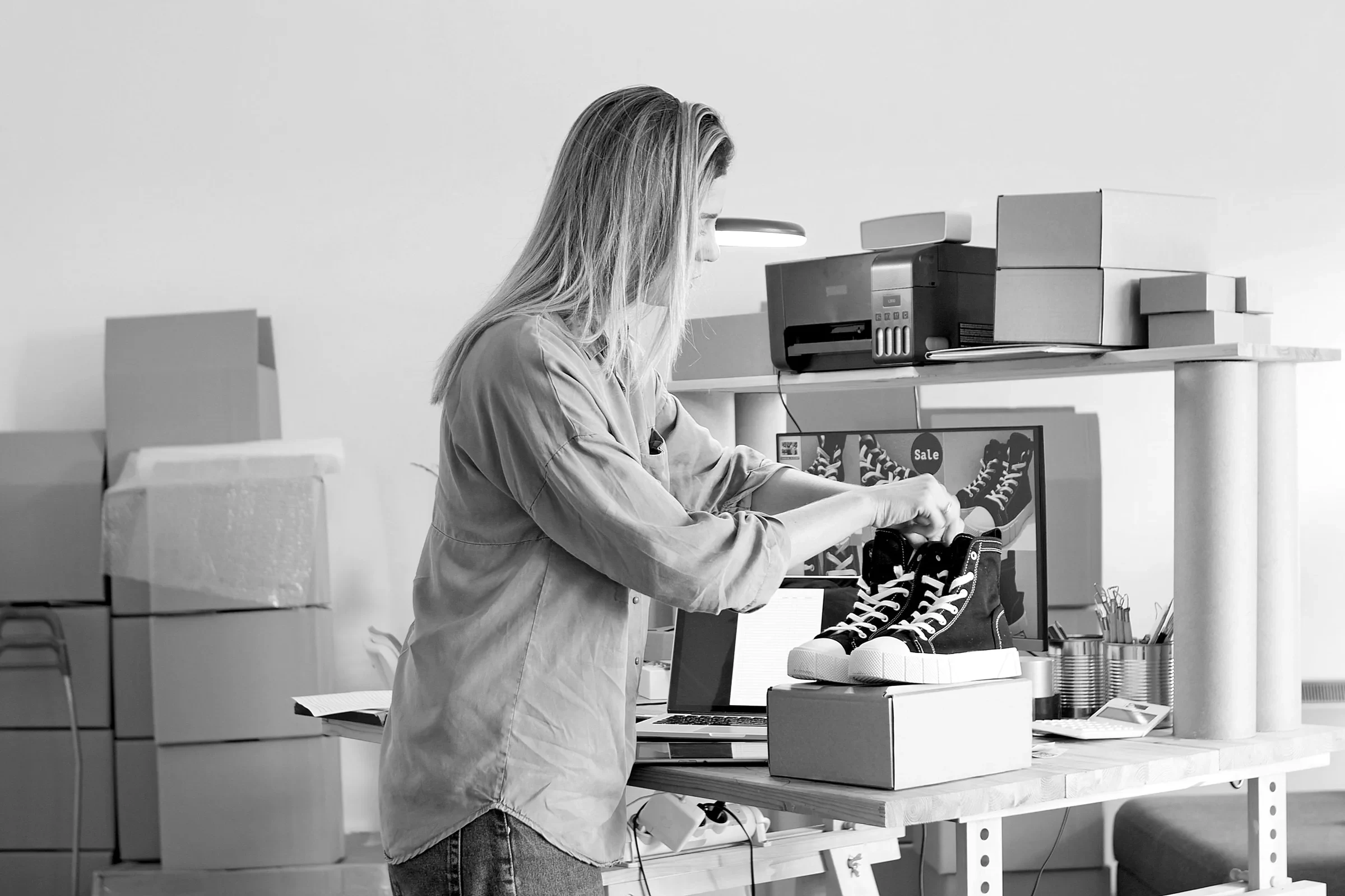 A store owner packing sneakers for an online order
