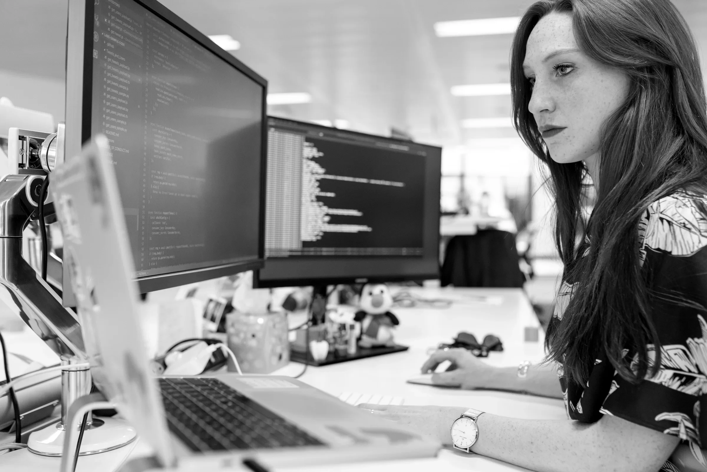 A developer auditing site code across monitors