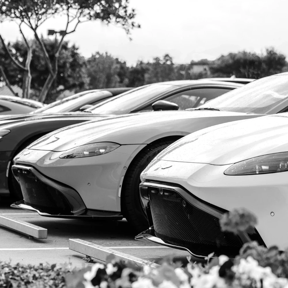 A row of sports cars in bright colours lined up on a dealership forecourt