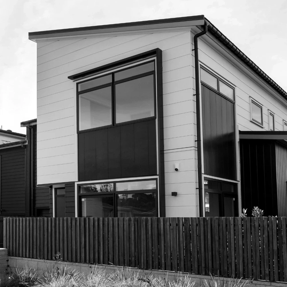 A row of newly built modern townhouses with dark cladding and large windows