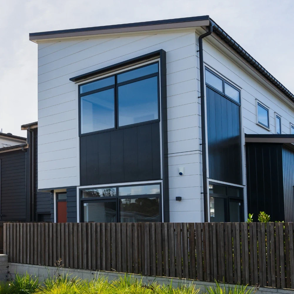 A row of newly built modern townhouses with dark cladding and large windows